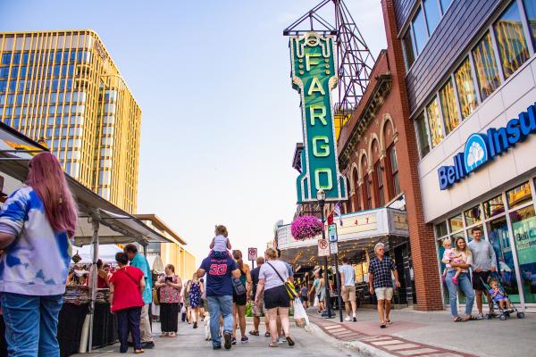 Families walk down Broadway in Downtown Fargo, during the Street Fair