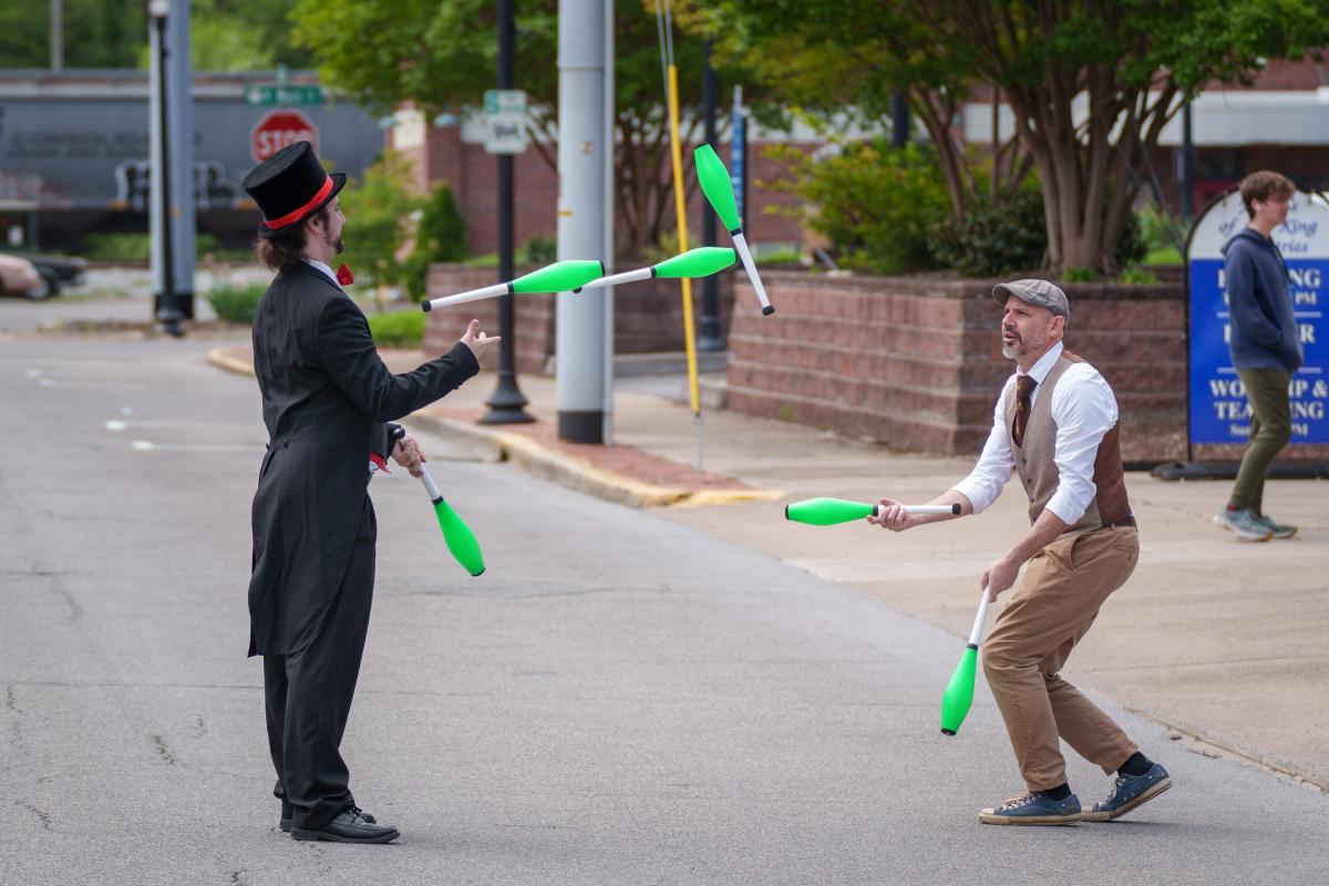 Two jugglers tossing clubs