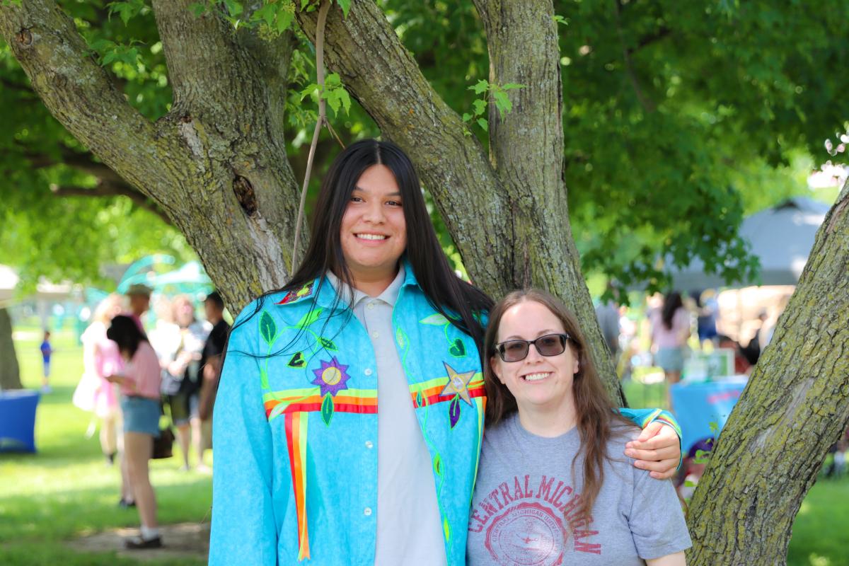 Two people embracing one another and smiling toward the camera at Mount Pleasant Pride Festival