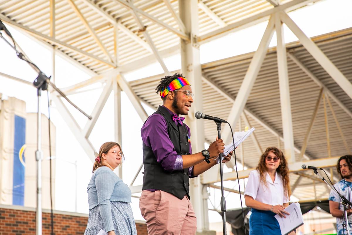 Great Lakes Bay Pride Festival performer speaking into the microphone on stage.