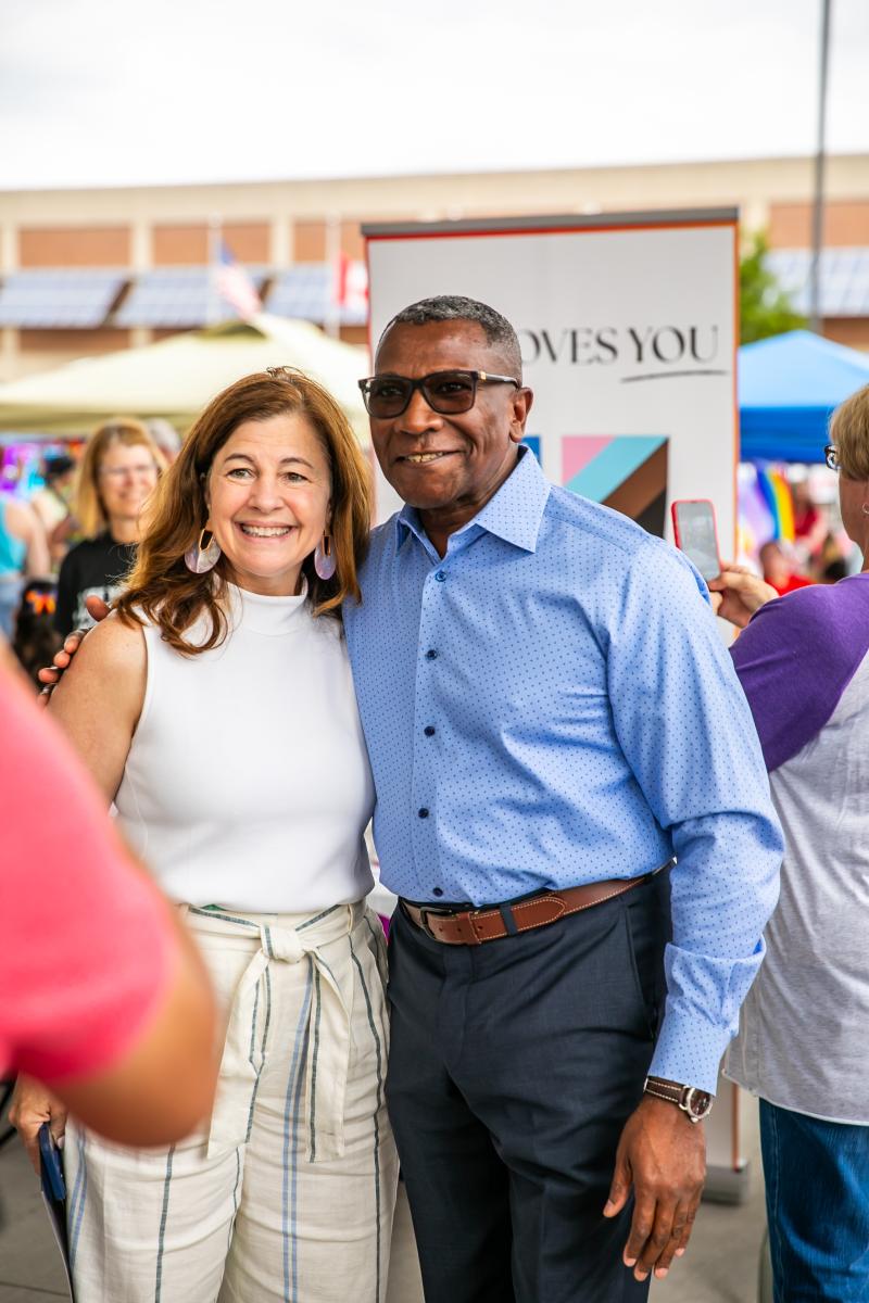Two people embracing one another and smiling toward the camera at Great Lakes Bay Pride Festival