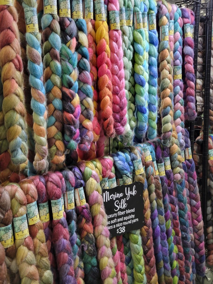 colorful braids of hand-dyed fiber on display in a booth