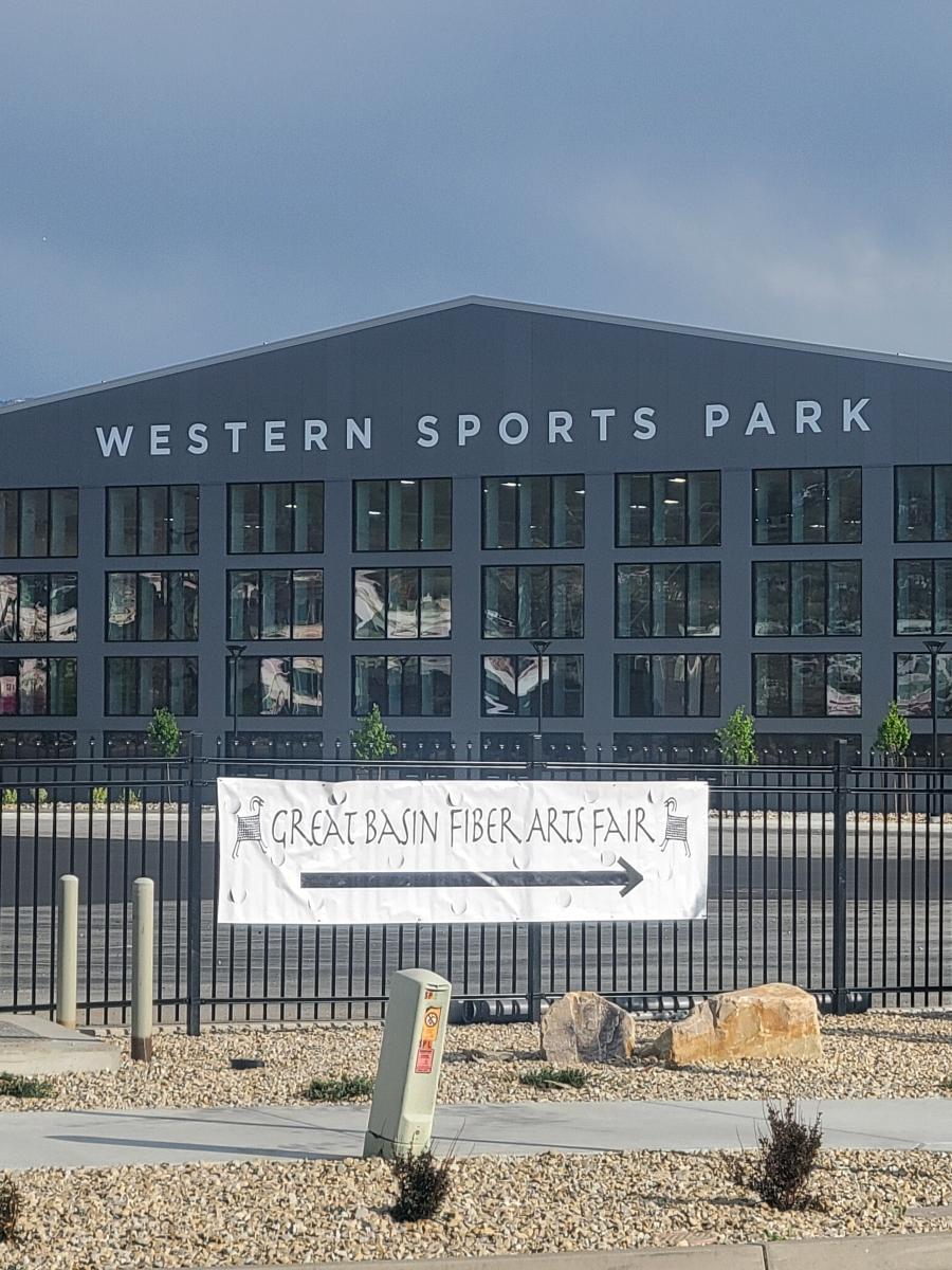 a grey building with a fence around it with the sign Western Sports Park