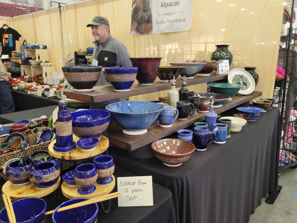 blue hand thrown pottery display in a booth