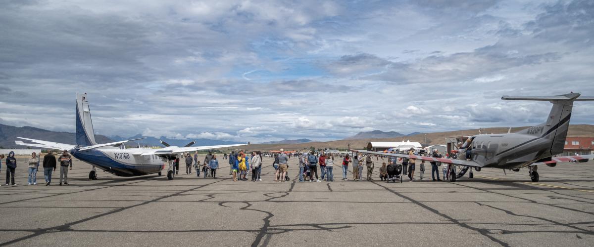 Crowd gathering between two airplanes.