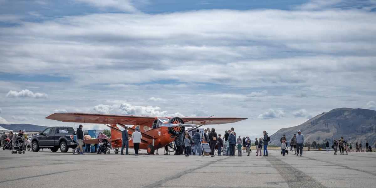 Miss Veedol, redish orange airplane, with a crowd around it.