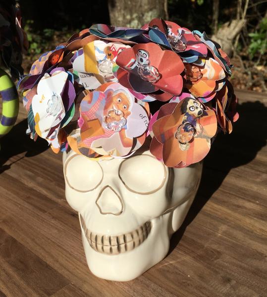 Coco little golden book hand-cut paper flower arrangement in Skull vase.