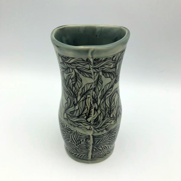 Ceramic vase with subtle gray green glaze over leaf imagery and texture picture