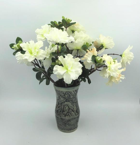 Ceramic vase with subtle gray green glaze over leaf imagery and texture