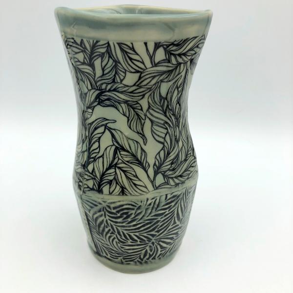 Ceramic vase with subtle gray green glaze over leaf imagery and texture picture