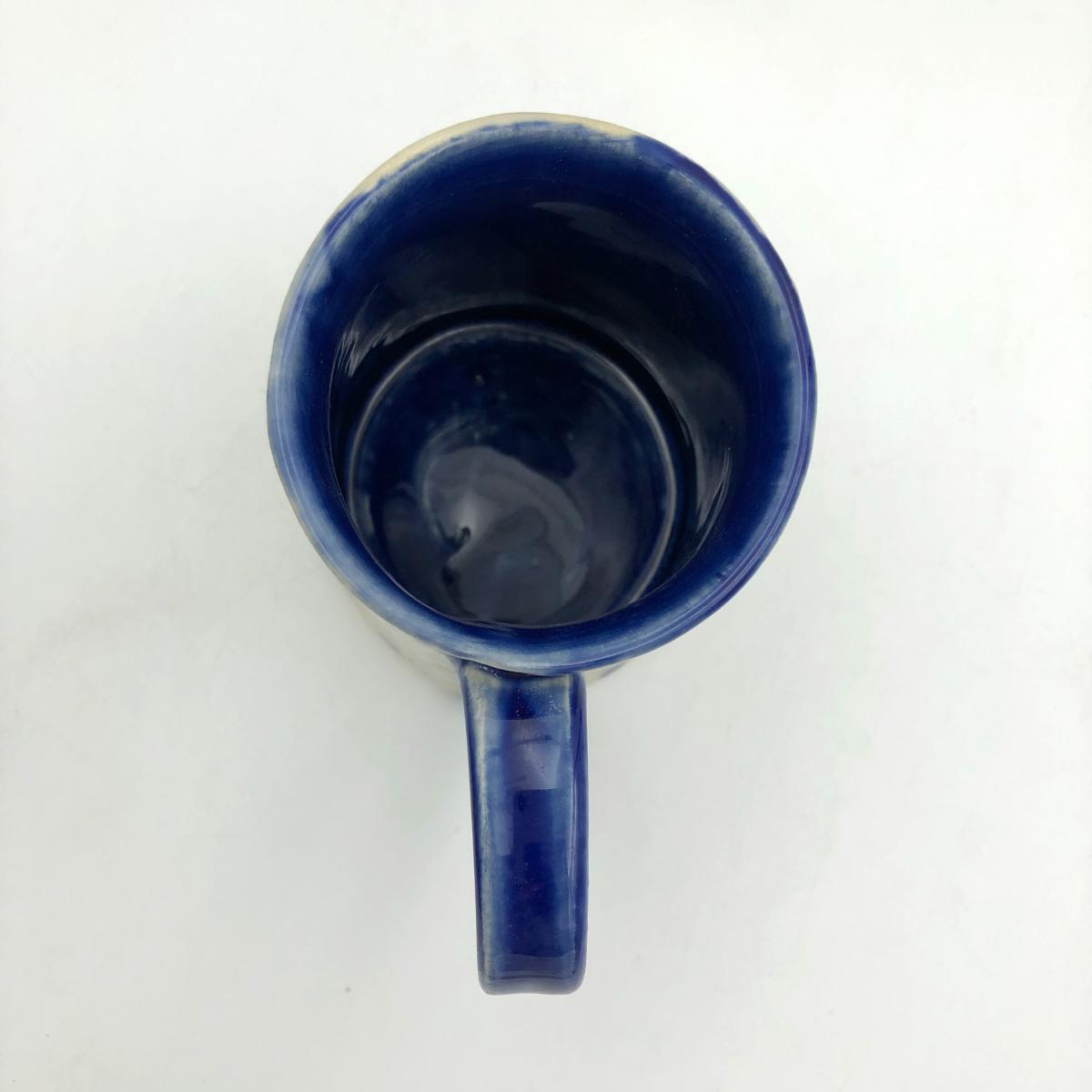 Handmade ceramic coffee mug with blurred blue flowers picture