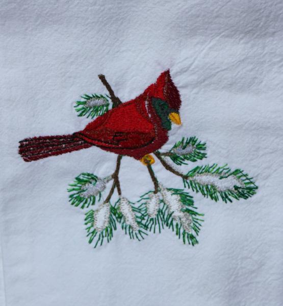 A red winter cardinal on a pine branch embroidered on a white flour sack tea towel, dish towel, cotton picture
