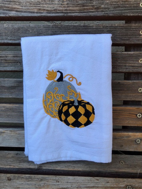 Elegant fall pumpkins are embroidered on a white flour sack tea towel, dish towel, cotton
