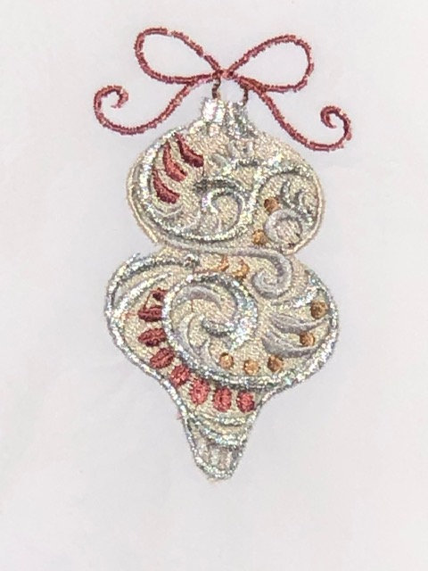 A Christmas ornament is embroidered on a white flour sack tea towel, dish towel, cotton picture