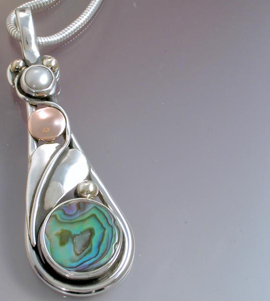 An abalone & pearl pendant with a leaf.