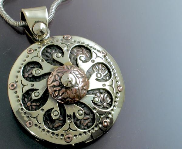 A mandala pendant of mixed metals