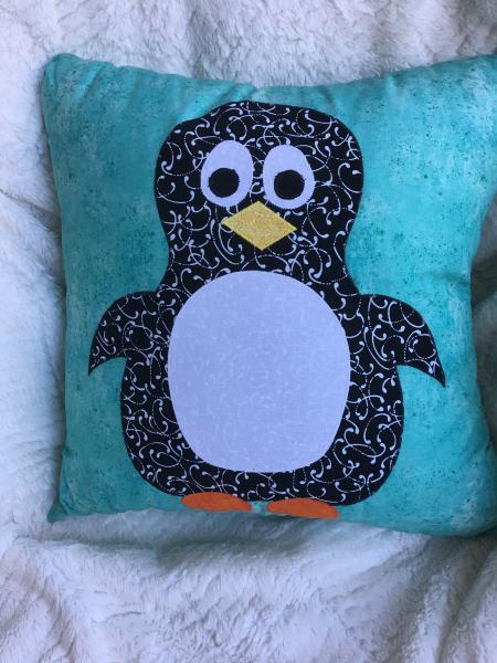 Penguin appliqué pillow on light teal background