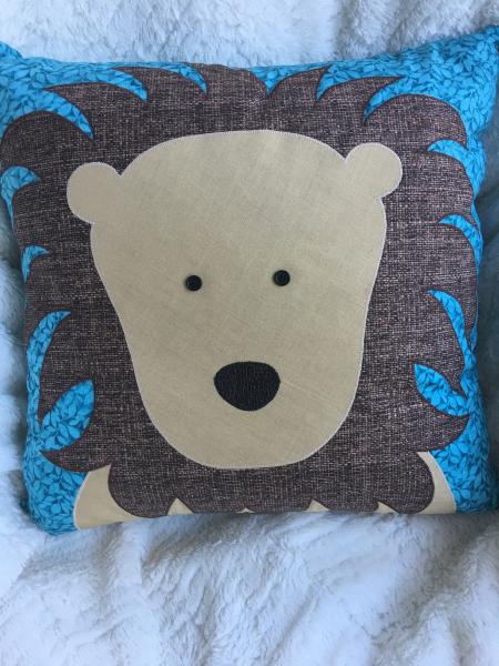 Lion appliqué on teal botanical pillow