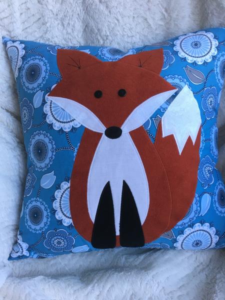 Fox pillow on blue floral background