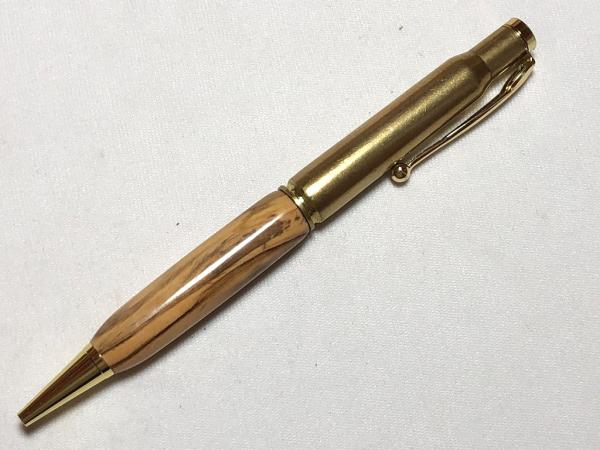 30.06 caliber bullet pen made with various woods, gold hardware, and a genuine casing