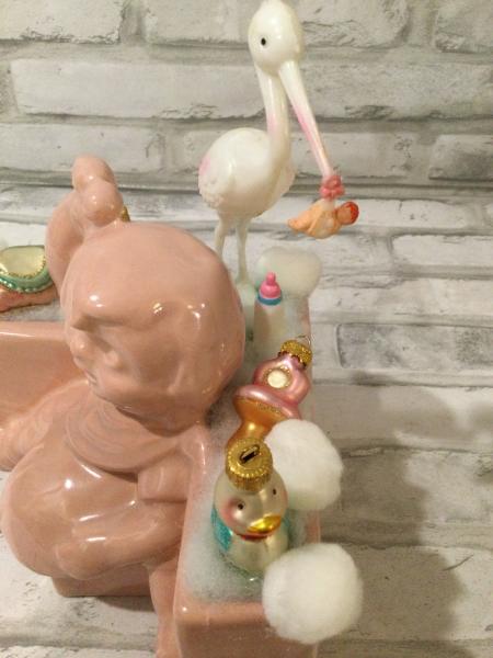 Antique baby girl planter filled with antique decorations picture