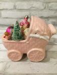 Antique pink baby carriage filled with antique decorations
