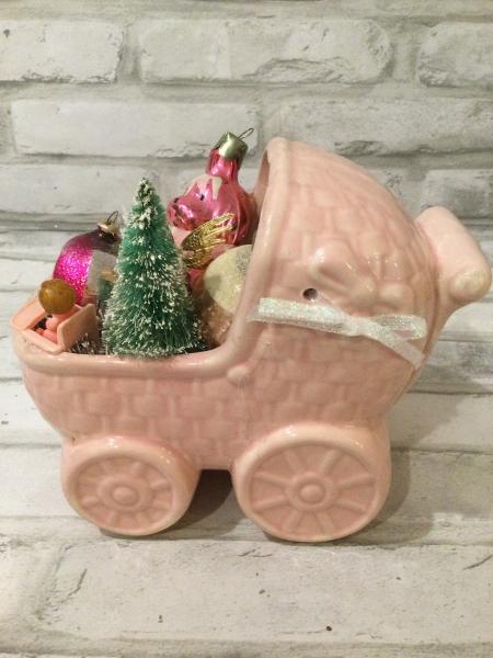 Antique pink baby carriage filled with antique decorations