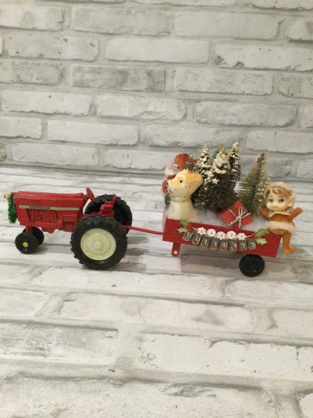 Red tractor and trailer filled with antique Christmas decorations and ornaments