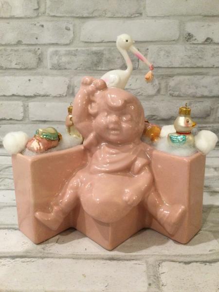 Antique baby girl planter filled with antique decorations picture