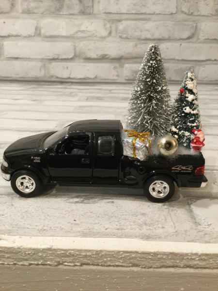 Black Ford truck filled with antique Christmas decorations picture