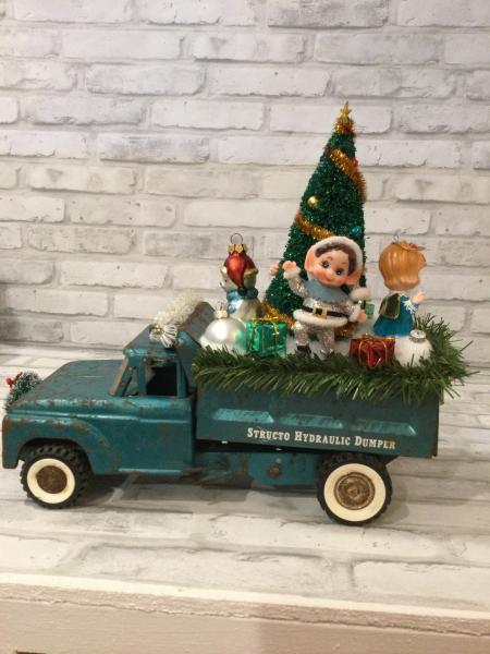 Antique teal dump truck filled with antique decorations picture