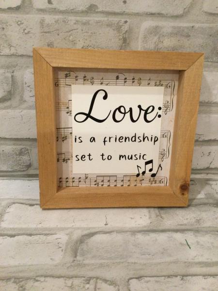 Framed sign saying Love: is a friendship set to music