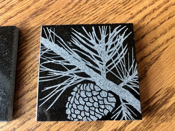 Etched pine cone on black granite drink coaster/tile picture